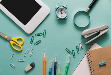 School set with notebooks, pens, laptop, scissors, stapler, magnifying glass on a blue background. Back to school concept. template for design