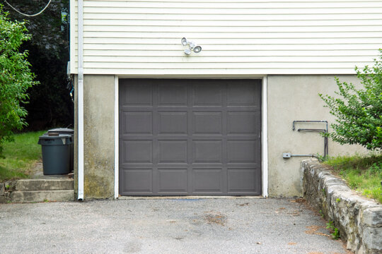 ONE DOOR GARAGE PAINTED IN BROWN COLOR< BUILT AS AN ADITION TO A RESIDENTIAL HOUSE