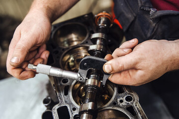 measuring instrument in hands against the background of the engine at a shallow depth of field