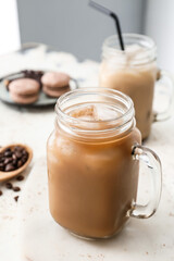 Board with mason jar of tasty iced coffee on table
