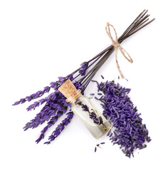 Bottle of lavender essential oil and flowers on light background