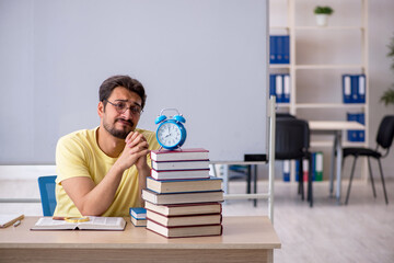 Young male student preparing for exams in the classroom