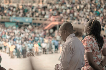 african couple at a church conference praying in a crowd