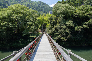 山間を流れる川に架けられた木製の吊り橋