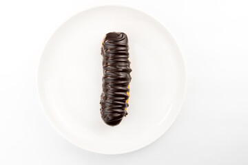 Dessert Bomba de Chocolate. Brazilian traditional éclair on a white background. Close-up macro. Selective focus.