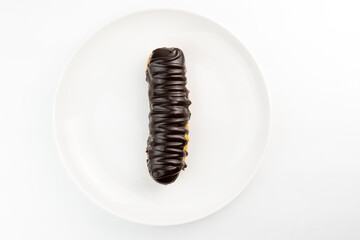 Dessert Bomba de Chocolate. Brazilian traditional éclair on a white background. Close-up macro. Selective focus.
