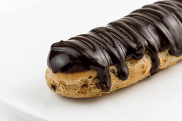 Dessert Bomba de Chocolate. Brazilian traditional éclair on a white background. Close-up macro. Selective focus.