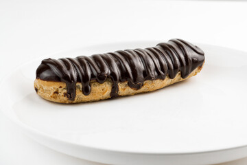 Dessert Bomba de Chocolate. Brazilian traditional éclair on a white background. Close-up macro. Selective focus.