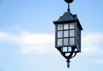 Fototapeta na wymiar Ancient street lamp against blue sky, close up. Copy space.