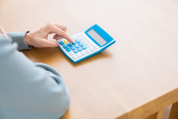 電卓を持つ女性　手元　ボディパーツ