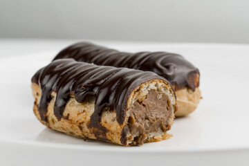 Dessert Bomba de Chocolate. Brazilian traditional éclair on a white background. Close-up macro. Selective focus.