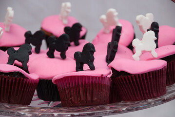Chocolate cupcakes with pink fondant and a dog on top