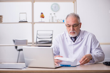 Old male doctor working in the clinic