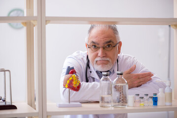 Old male doctor cardiologist working in the clinic