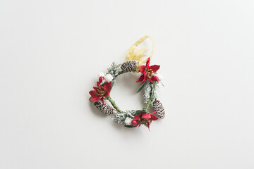 Flat lay of Christmas wreath on white background copy space minimal style. Christmas ornament for decoration in Christmas Eve, xmas new year festival.