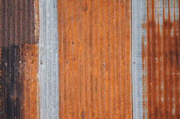 An old rusty metal sheet roof textured. Rust is an iron oxide formed by the reaction of iron and oxygen in the catalytic presence of water or air moisture. © boyloso