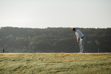 Golfers in a ready position plays swing shot on teeing ground in warm sunshine. leisure and sport...