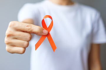 hand holding Orange Ribbon for Leukemia, Kidney cancer day, world Multiple Sclerosis, CRPS, Self...