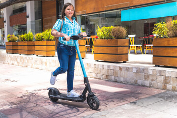 Blonde girl on the way to school on electric scooter © FABIAN PONCE GARCIA