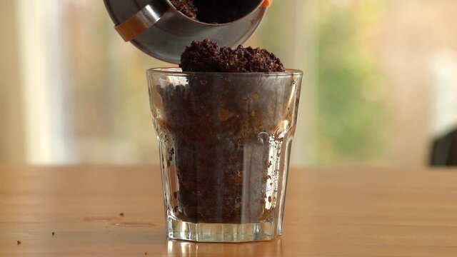 Collecting Used Coffee Grounds On Glass Cup