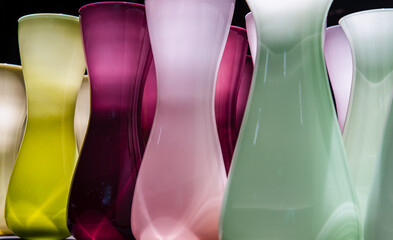 Vases for flowers are glass colored standing in a row with a perspective. Abstract glass vases color of a rainbow, No focus, specifically.