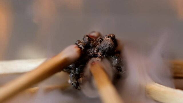 Slow motion of igniting matchsticks against black background.