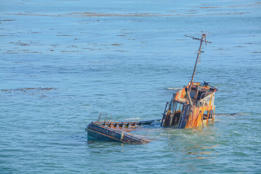 Ship wrecked fishing vessel on the rocks of Estero Bluffs State Park in San Luis Obispo County, California 