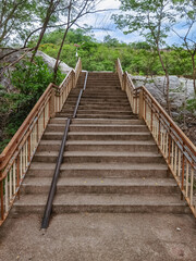Obraz premium Stair-safe bike ramp along stairs. Comfortable and safe lanes for bicycles on stairs. Old and rusted steel rails for bicycles up and down for comfort between steps on stairs in the public park.