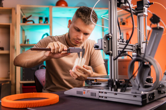 student in a workshop measures a detail printed on a 3D printer.