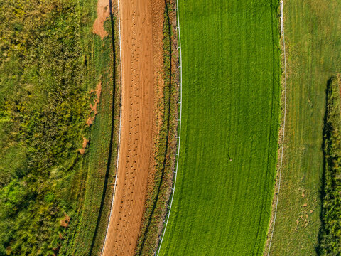 Aerial view of rural racetrack for racehorses empty in early morning light - Powered by Adobe