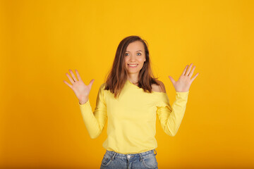 a young beautiful blonde girl in a yellow jacket and jeans shows emotions