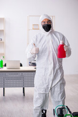 Fototapeta premium Young male contractor disinfecting office during pandemic