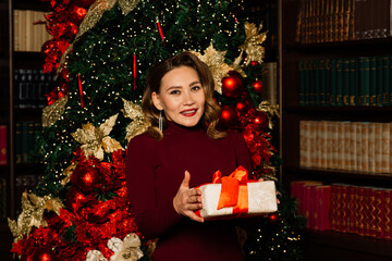 Christmas, x-mas, winter, happiness concept - smiling woman in santa clothes with many gift boxes