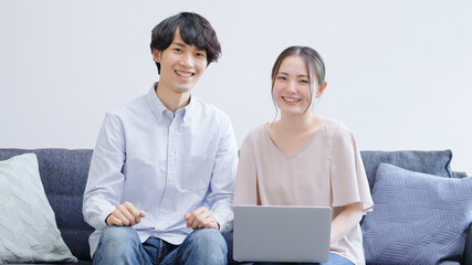 パソコンを使う若い夫婦・カップル