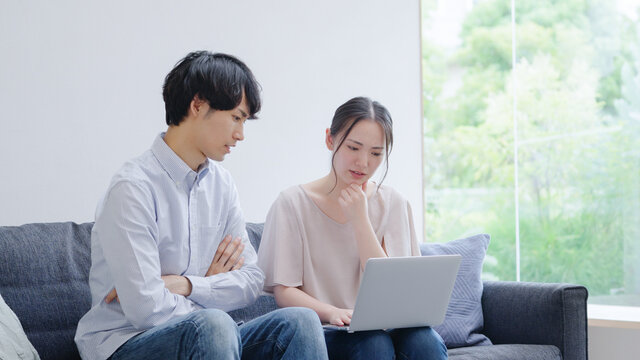 パソコンを使う若い夫婦・カップル