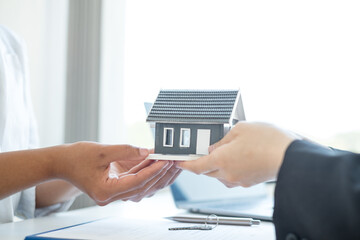 Real estate agent broker hand over the home to the new owner after completing the signing according to agreement renting a house and buy house insurance Home insurance concept