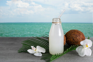 Coconut water in a transparent bottle on the background of the sea