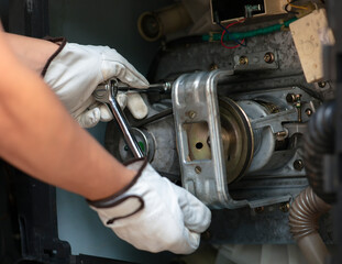 technician wearing glove using wrench repair wahsing machine at home