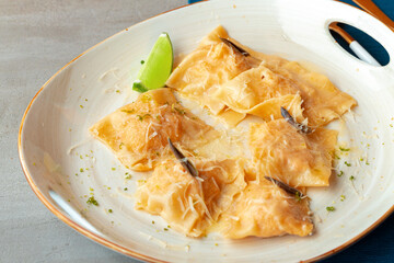Italian dish ravioli with parmesan in a plate