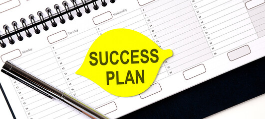 Text SUCCESS PLAN , on the yellow sticker on the planning