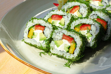Vegeterian sushi roll with dill and vegetables on wooden background