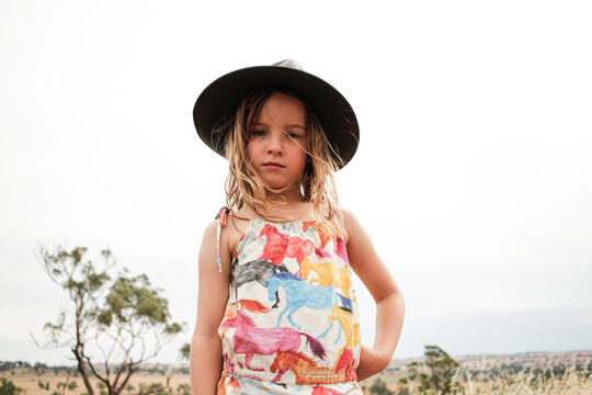 Young girl wearing grey bushman's hat in grassy fields