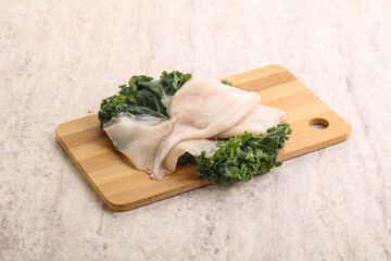 Raw squid over wooden board