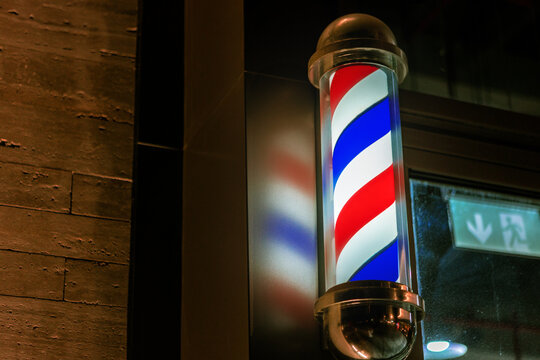 Barbershop Pole Sign Attached To A Wall Of Building