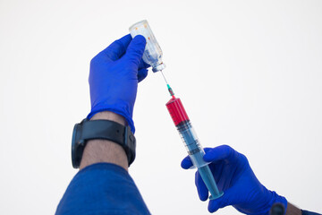 A doctor filling a syringe from the bottle for vaccination
