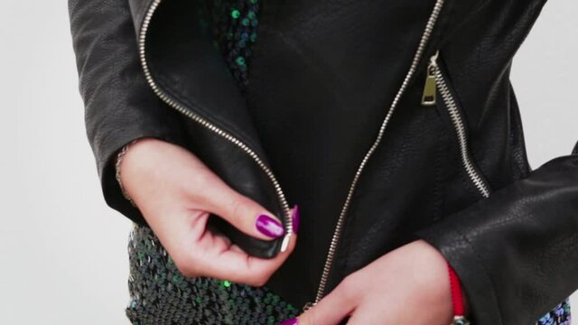 Women hands open the zipper on a black women's leather jacket. Video