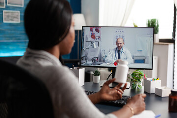 African american patient discussing with therapist doctor during online videocall meeting...