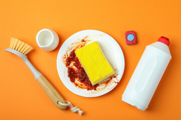 Concept of Dishwashing detergent accessories on orange background