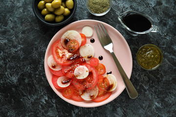 Concept of tasty food with tomato carpaccio on black smokey table