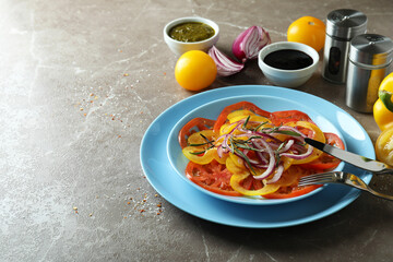 Concept of tasty food with tomato carpaccio on gray textured table